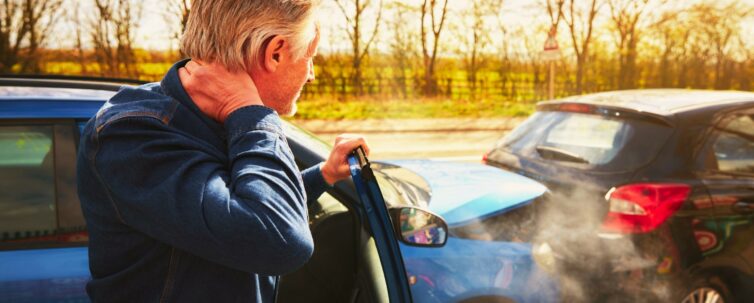 man looking at a crash of two cars