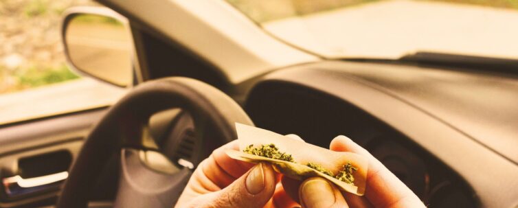 Man smoking marijuana in a vehicle, driving a car under the influence of cannabis