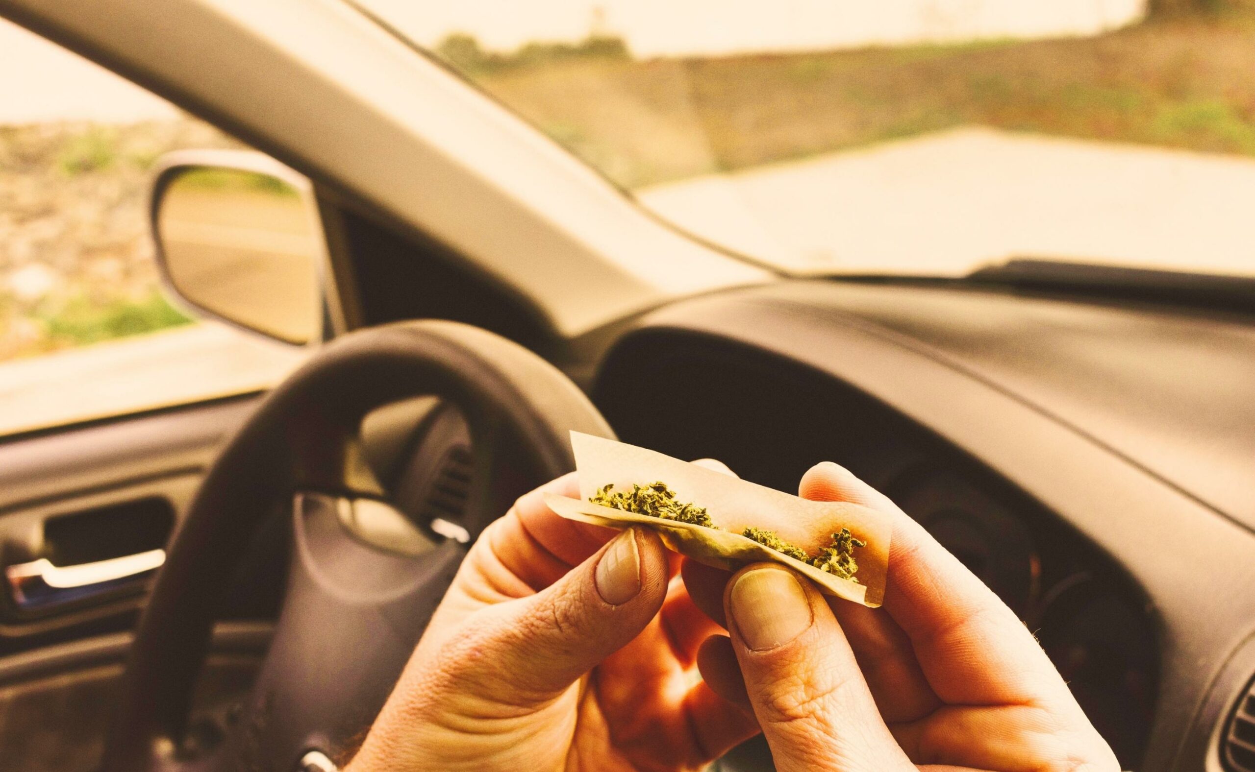 Man smoking marijuana in a vehicle, driving a car under the influence of cannabis