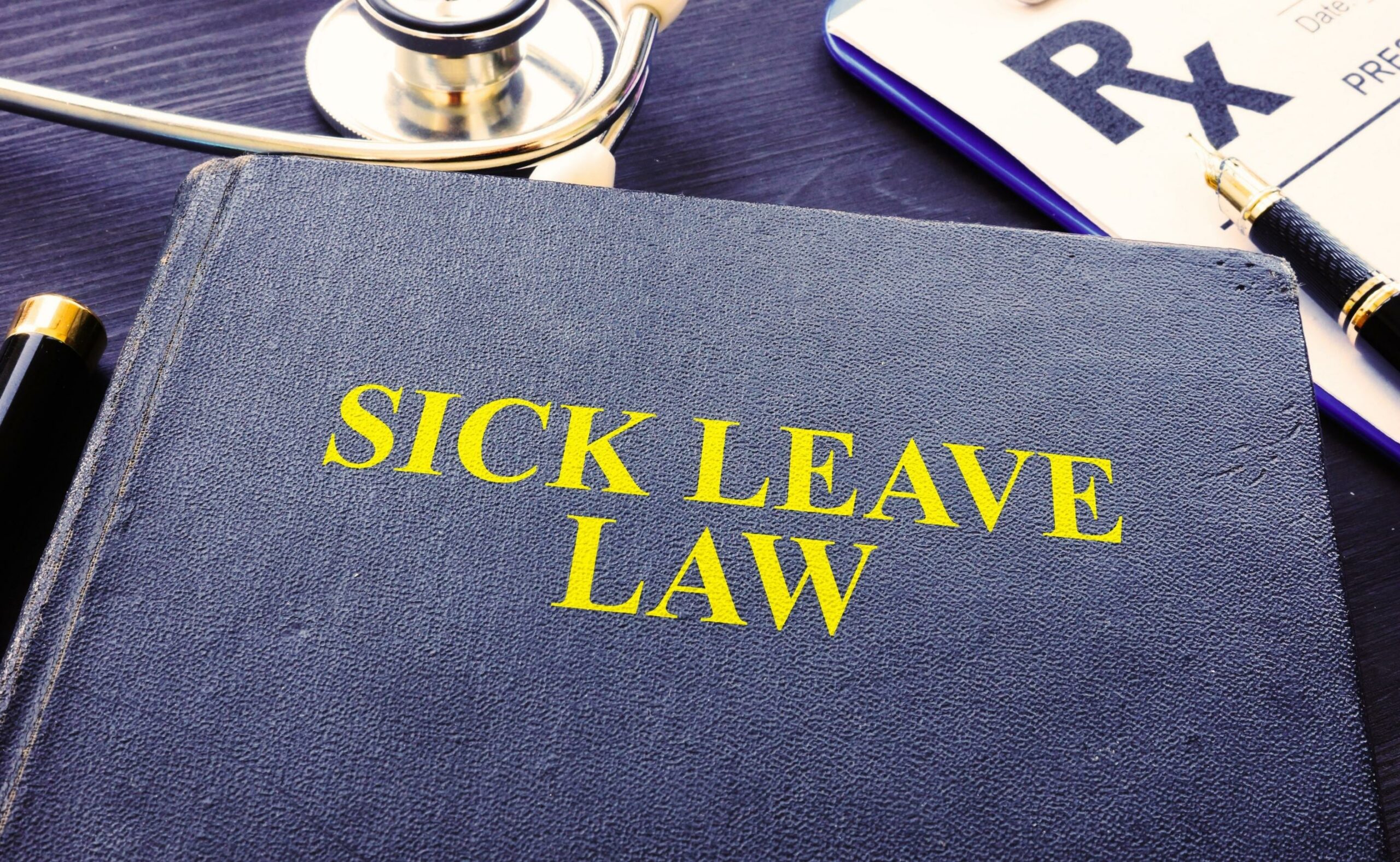 Sick leave law book and stethoscope