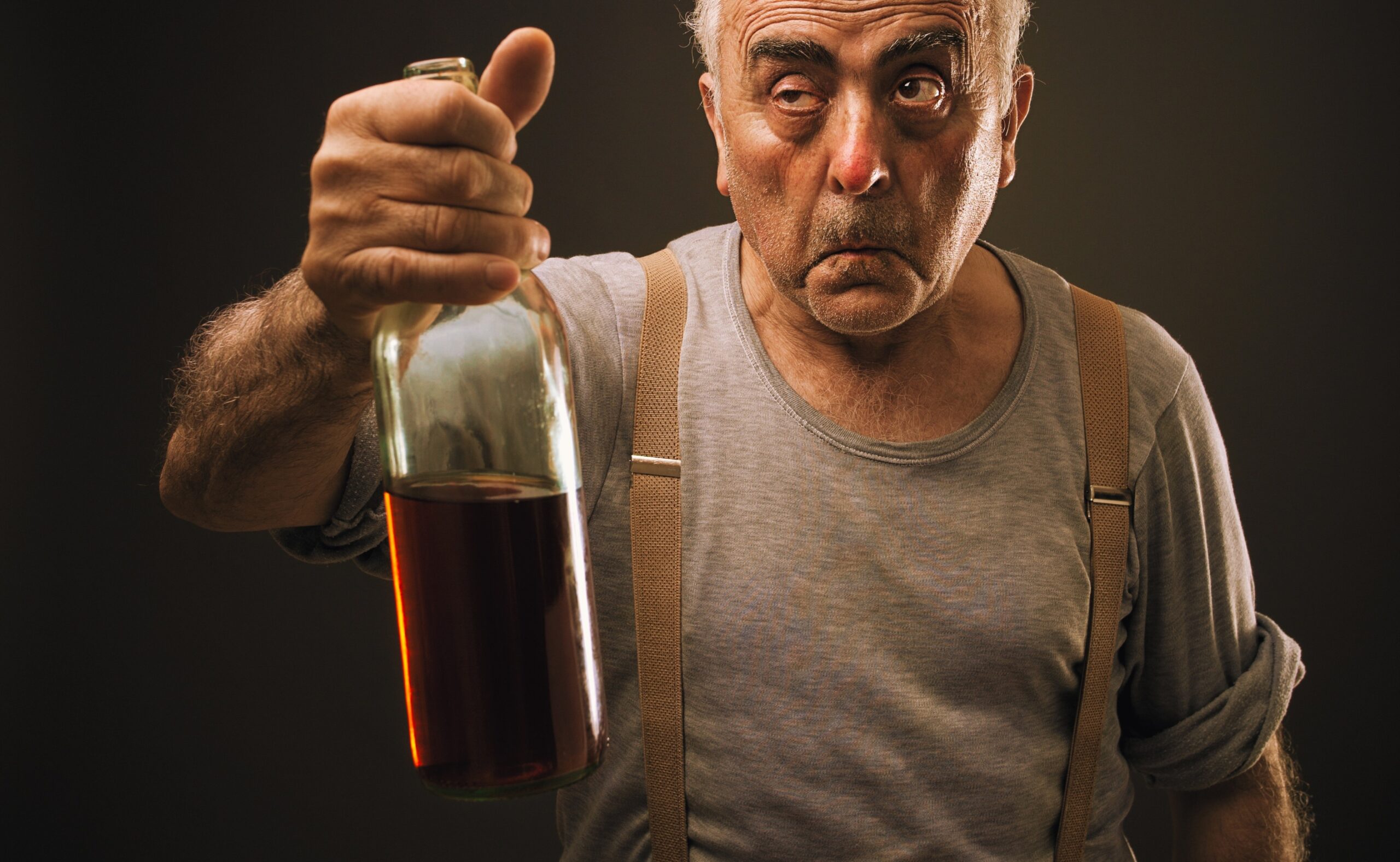 drunk old man holding a bottle