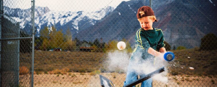child hitting a ball off a t-ball stand