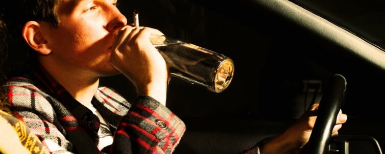 teenager drinking alcohol inside a car