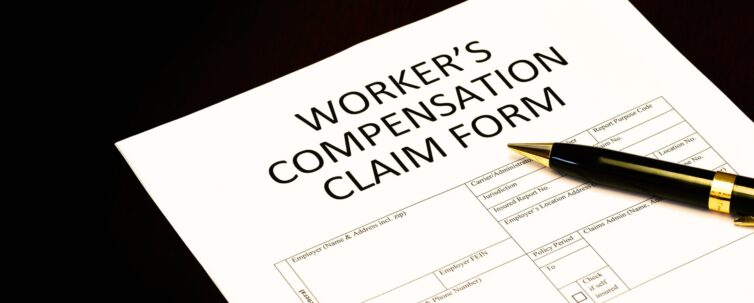 Workers' compensation claim form application with pen on desk