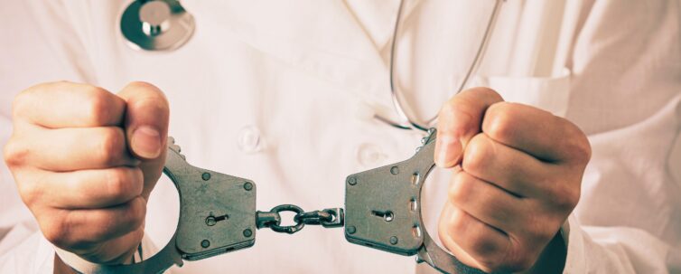 Handcuffed doctor, close-up. Medical malpractice and error concept
