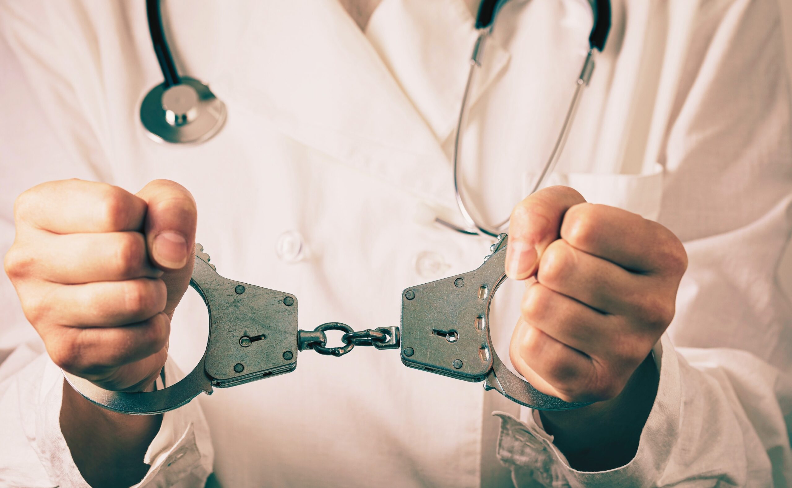 Handcuffed doctor, close-up. Medical malpractice and error concept