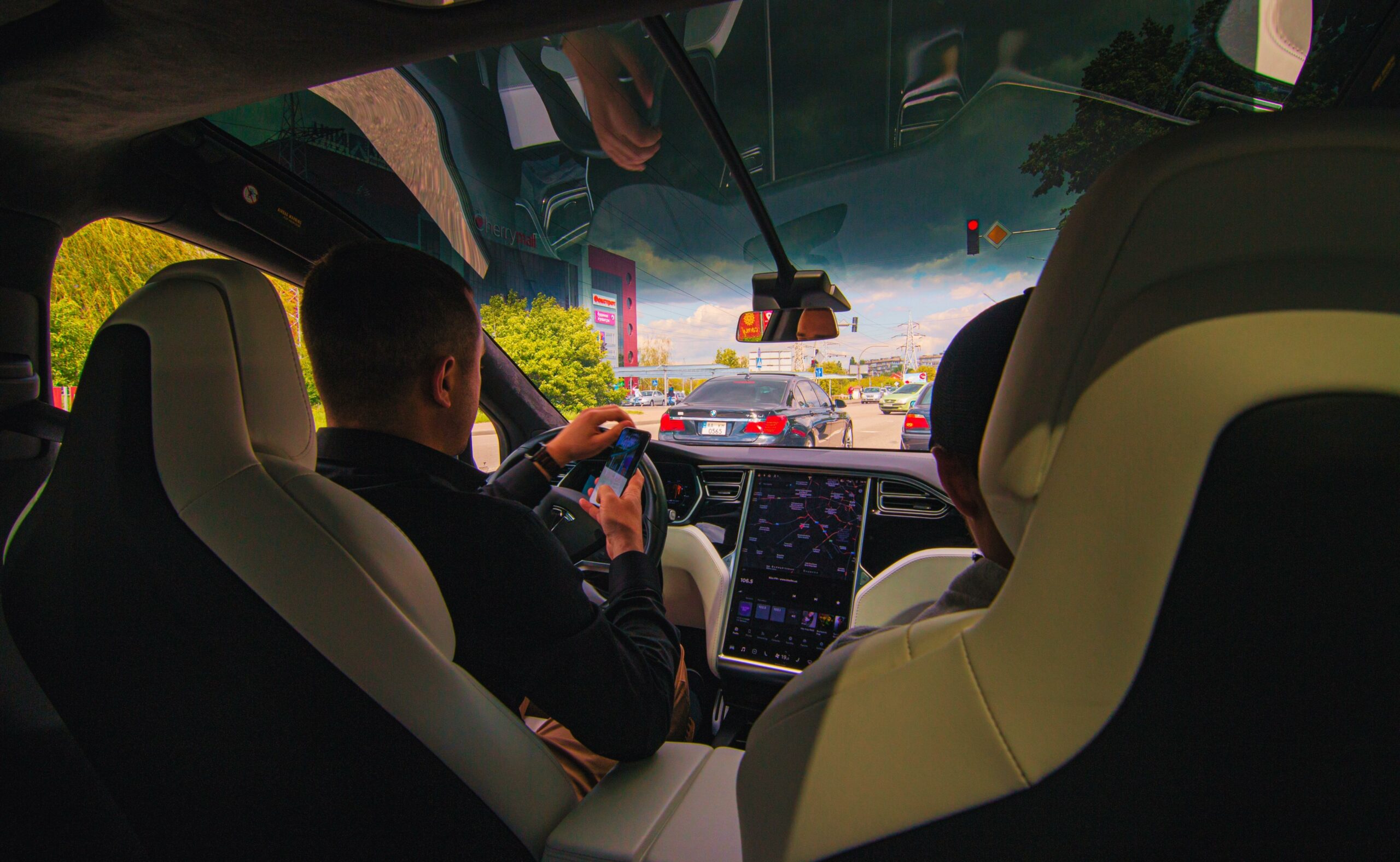 People inside a smart car, driver not doing smart thing.