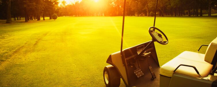 Golf cart in a beautiful sunset on the background