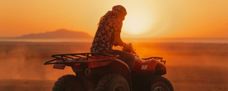 Man riding atv on the desert at sunset