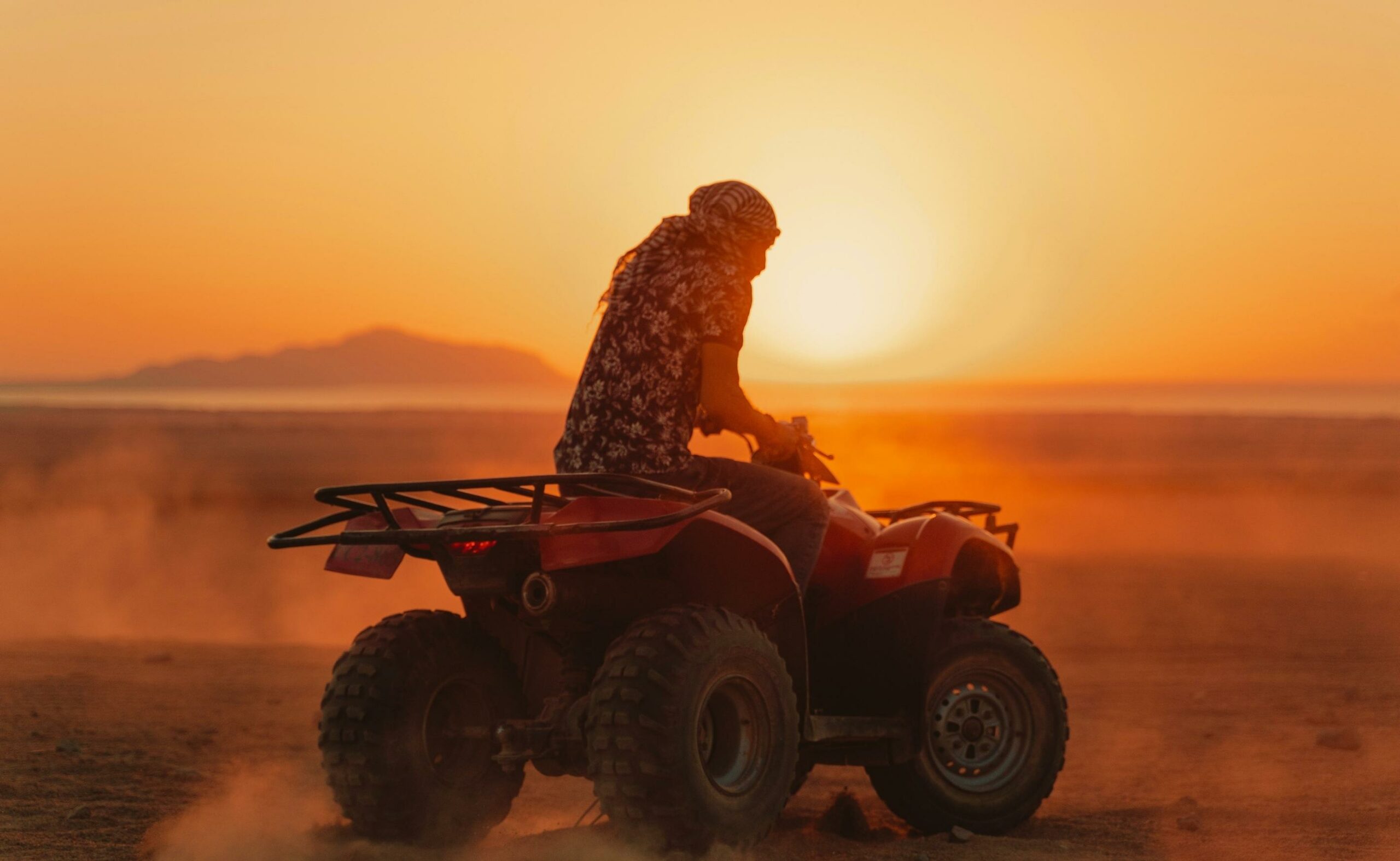 Man riding atv on the desert at sunset
