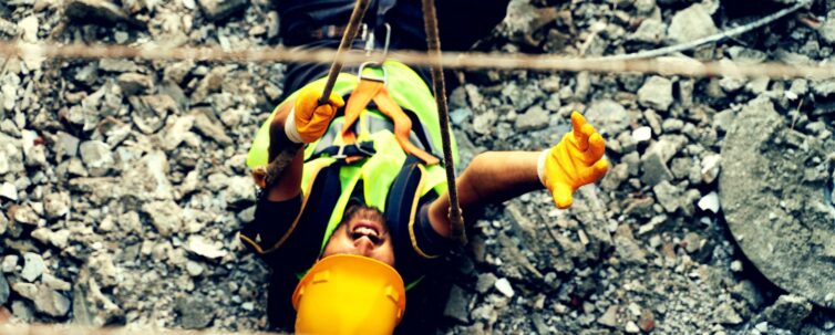 construction worker wearing safety vest and yellow helmet falls on site