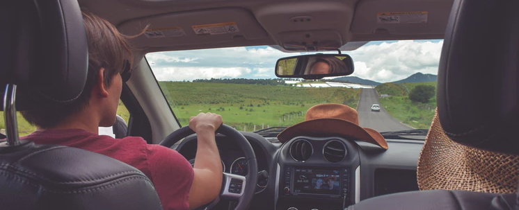 a man driving with the sunroof open