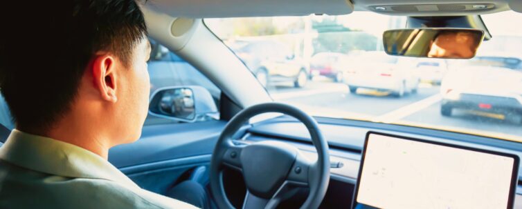 Asian relaxed man experience to riding an autonomous self driving electric car and using autopilot