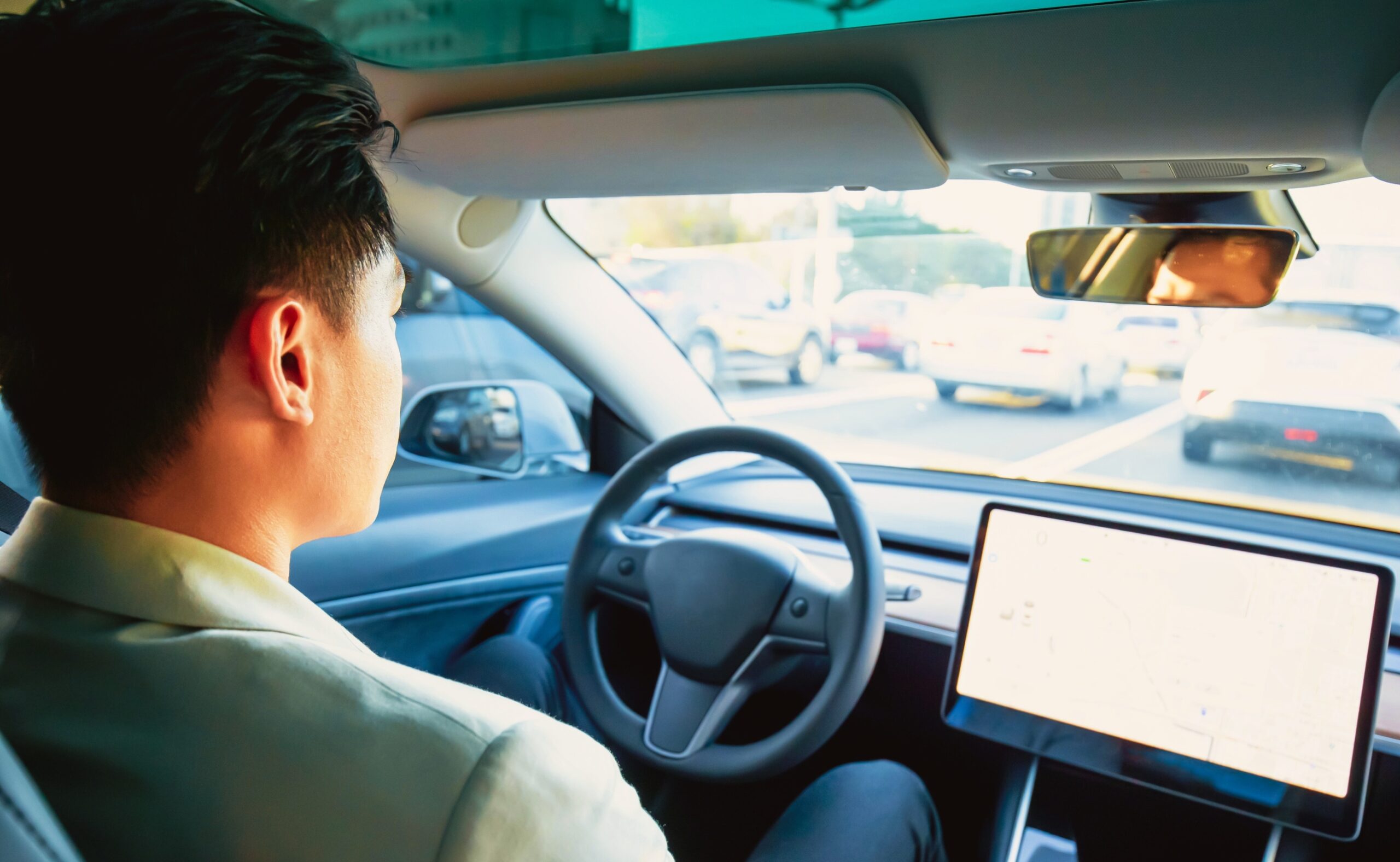 Asian relaxed man experience to riding an autonomous self driving electric car and using autopilot