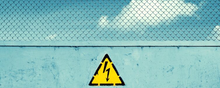 obstruction to mark unsafe, high voltage and grid. Danger of death. The sky behind the fence.