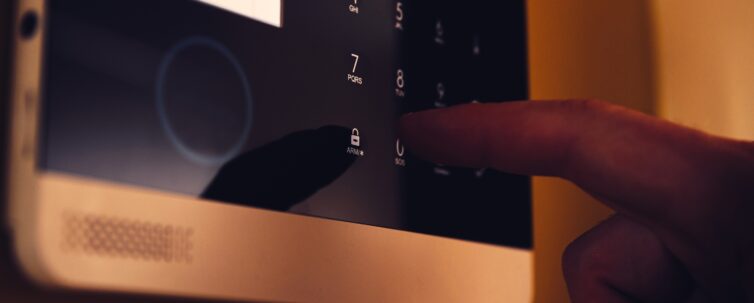 Man arming home security alarm, home alarm security control panel