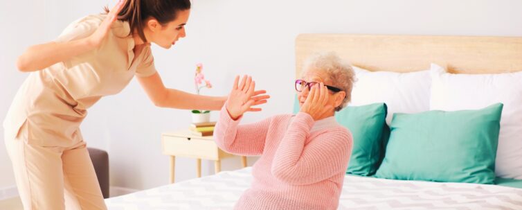 caregiver mistreating senior woman in nursing home