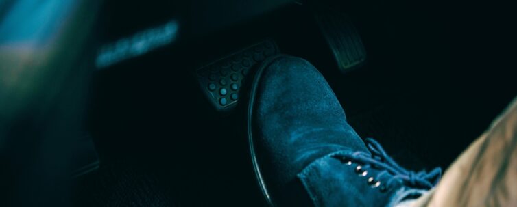 A foot stepping on a car brake