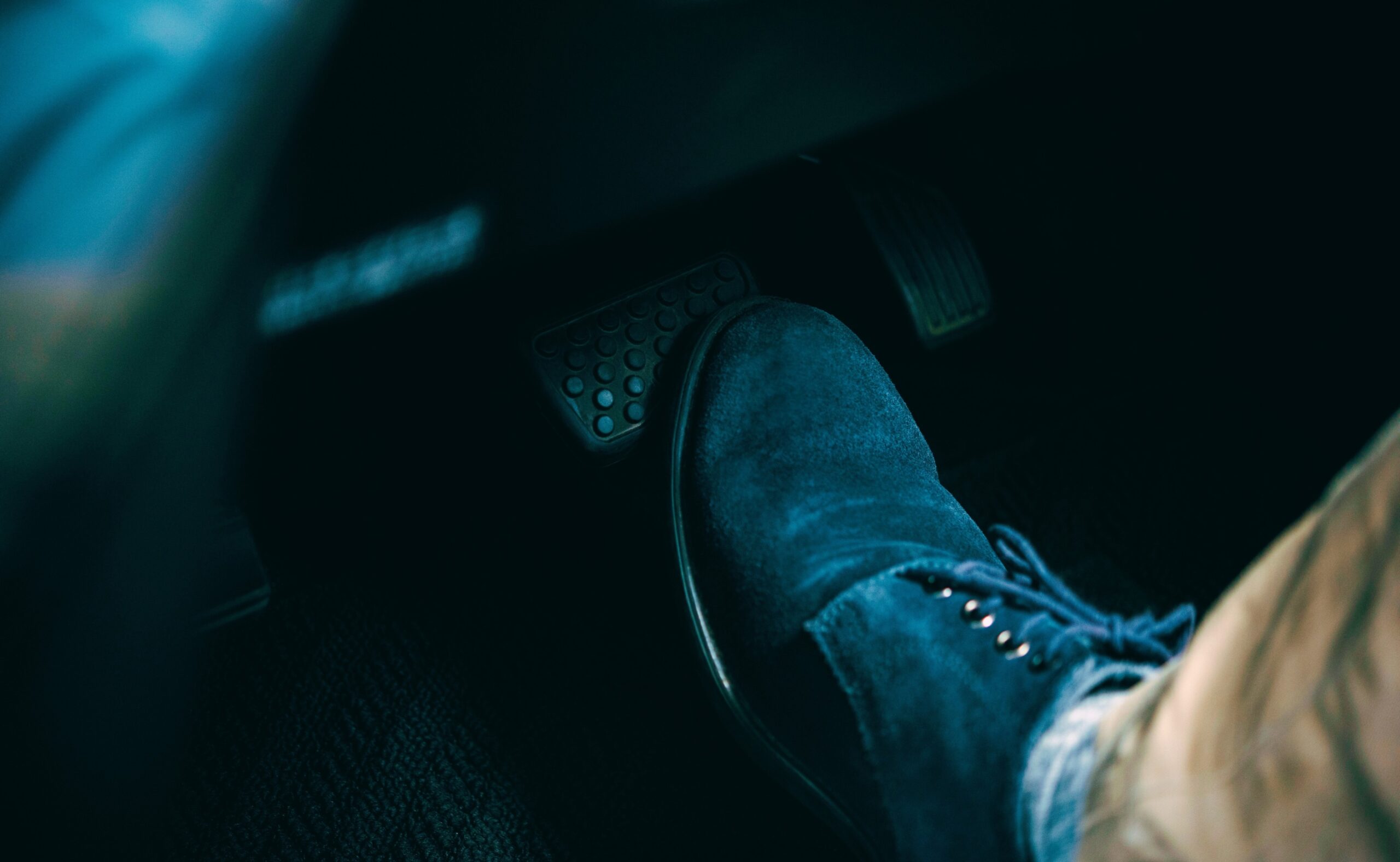 A foot stepping on a car brake