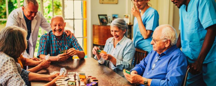 Group of senior people playing cards in nursing home