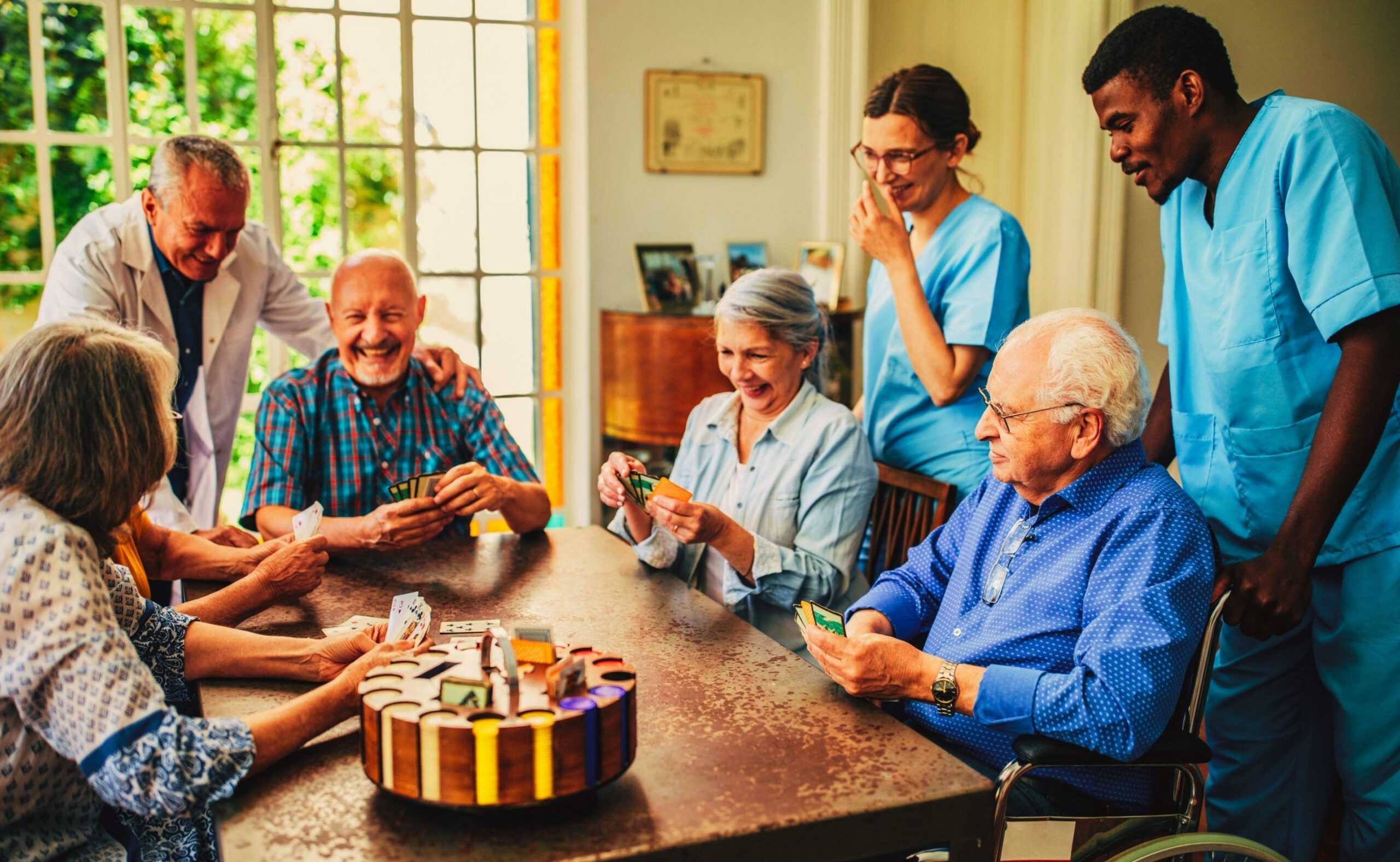 Group of senior people playing cards in nursing home