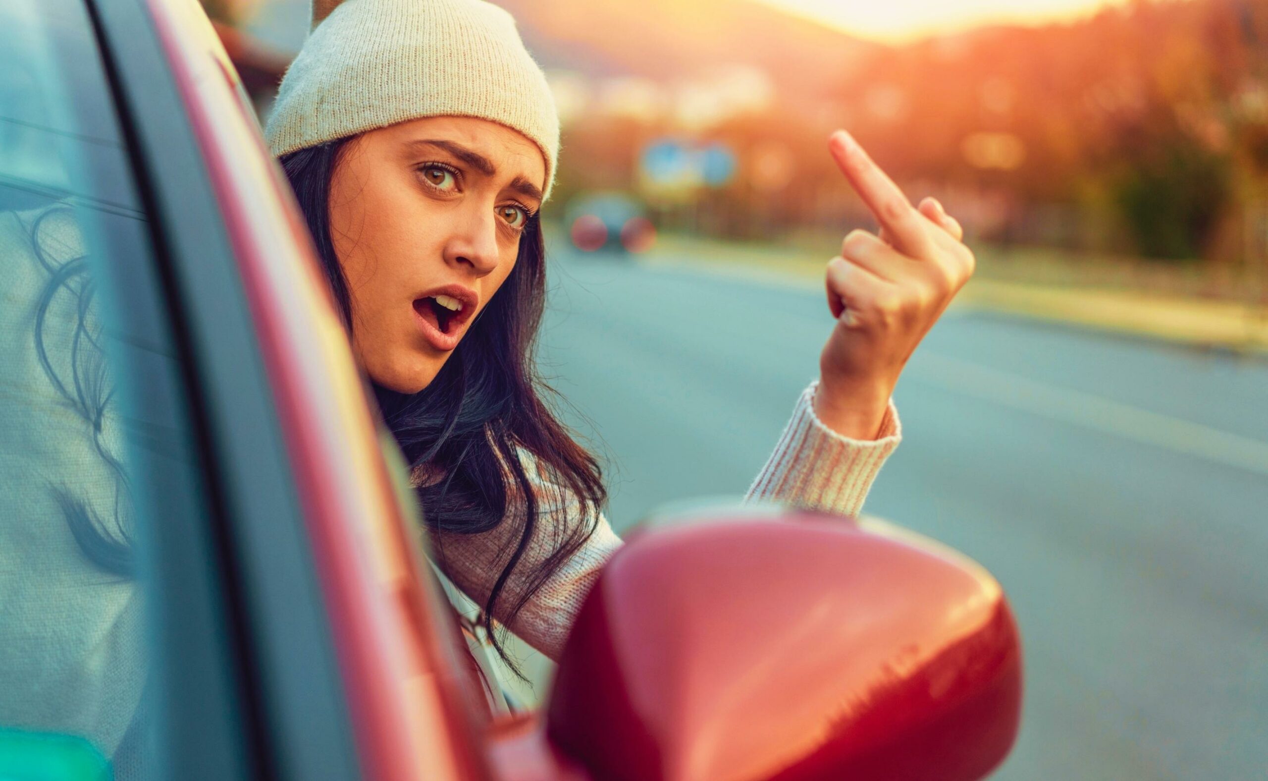 Young female using obscene gesture while driving