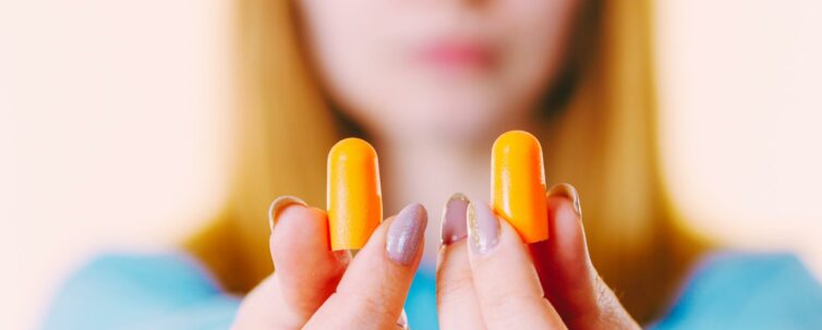 Woman holding protective ear plugs.