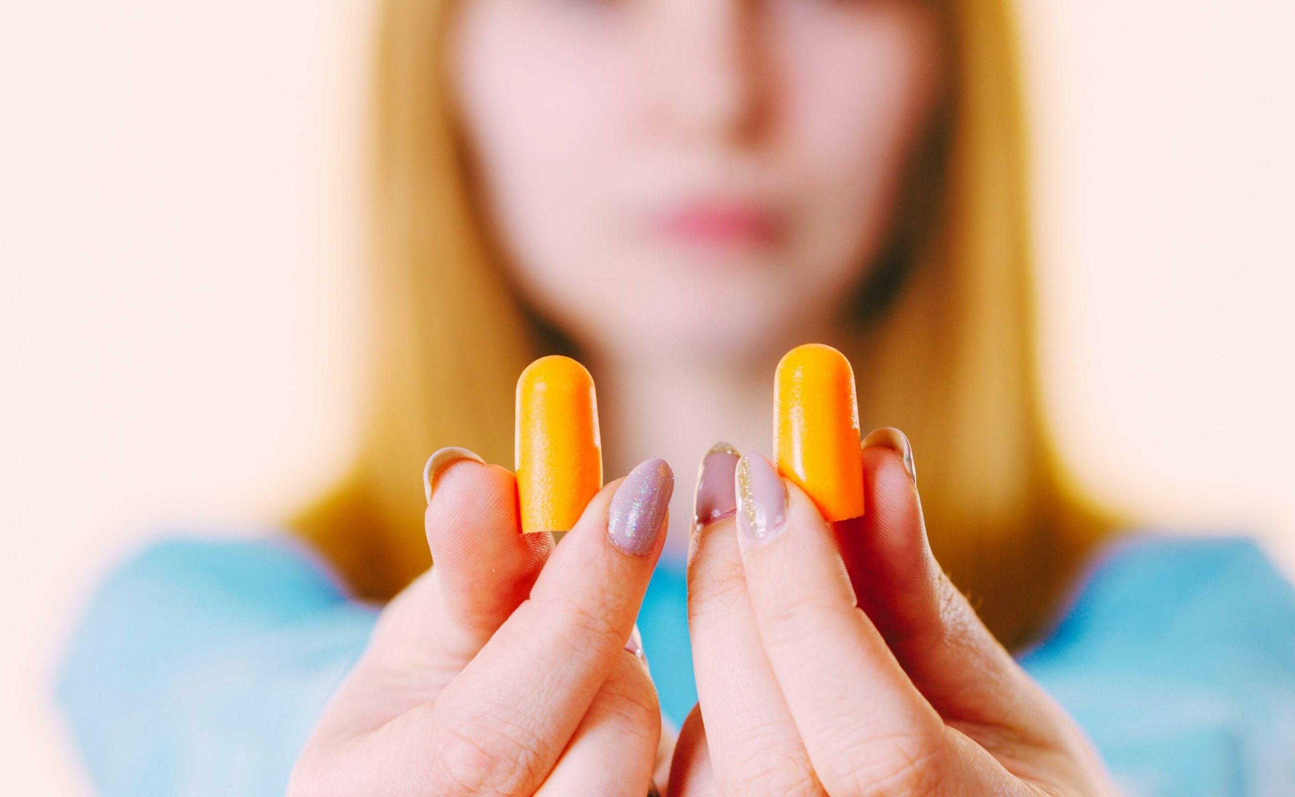 Woman holding protective ear plugs.
