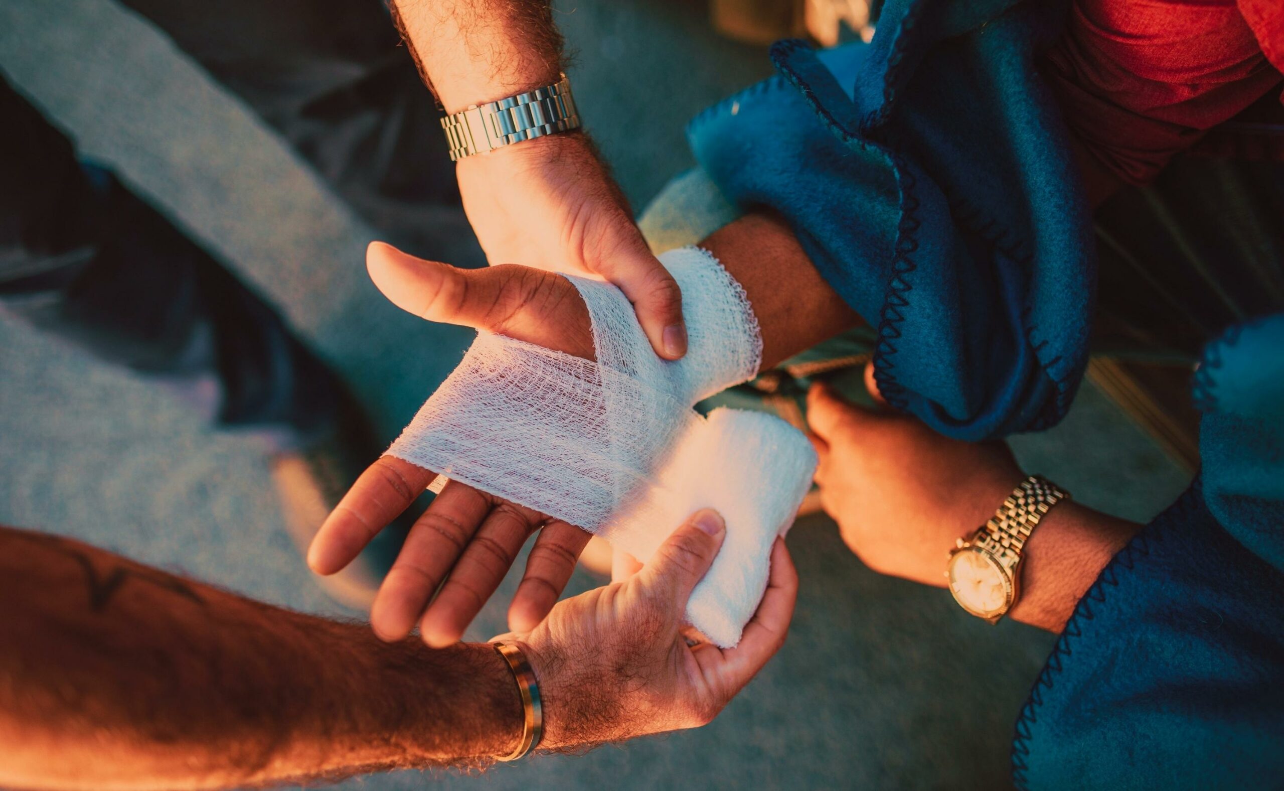 Medic applying bandage on worker's hand after injury