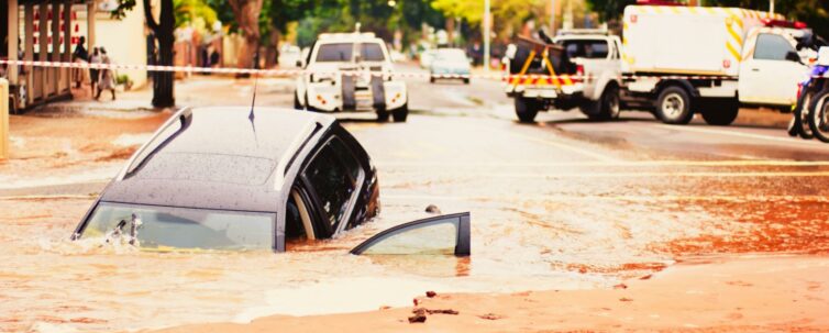 Car sinks into pothole in flooded urban road