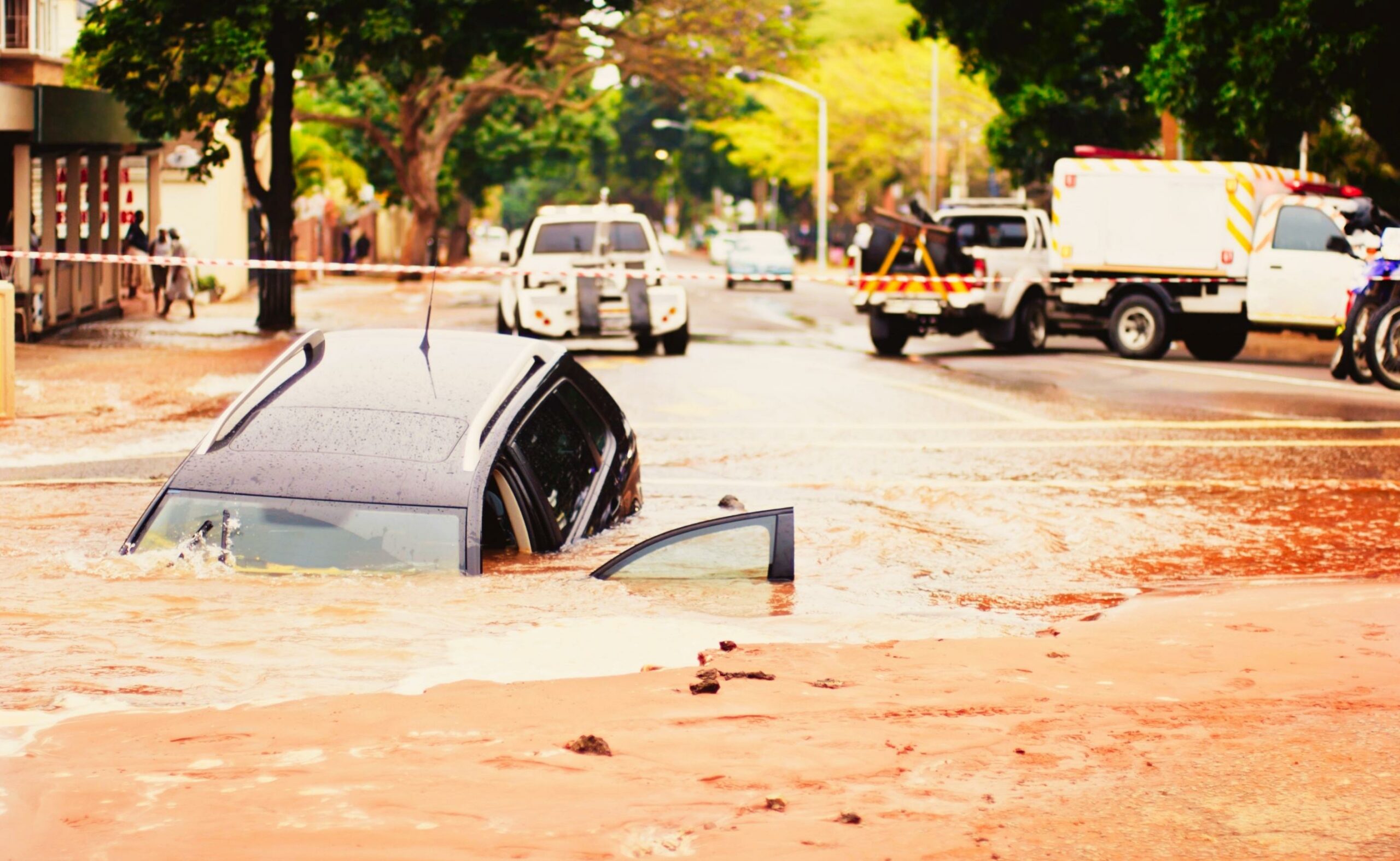 Car sinks into pothole in flooded urban road