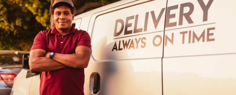Man in Red and Black Polo Shirt Standing Beside White Van