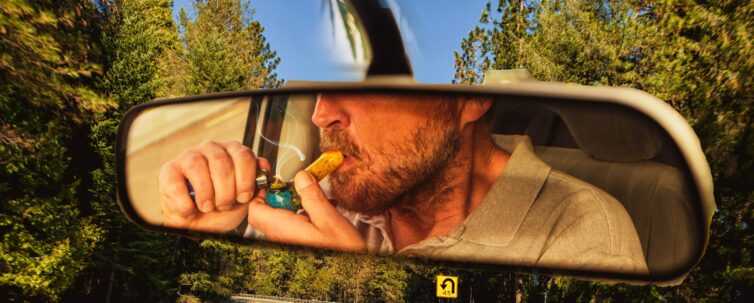 man smoking marijuana in a vehicle while driving a car