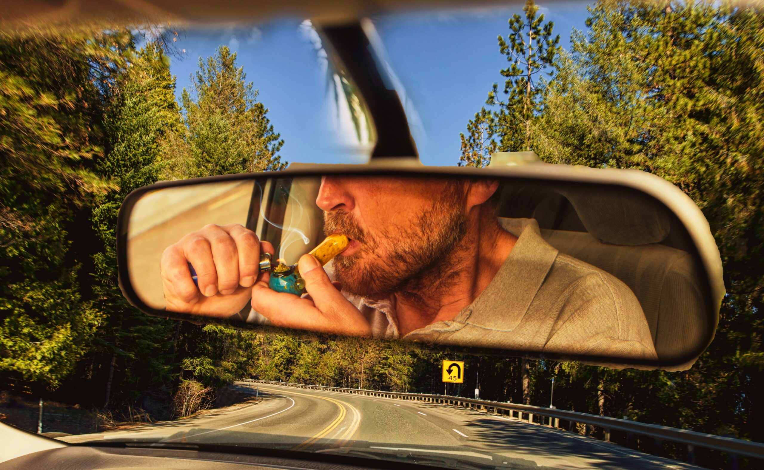man smoking marijuana in a vehicle while driving a car