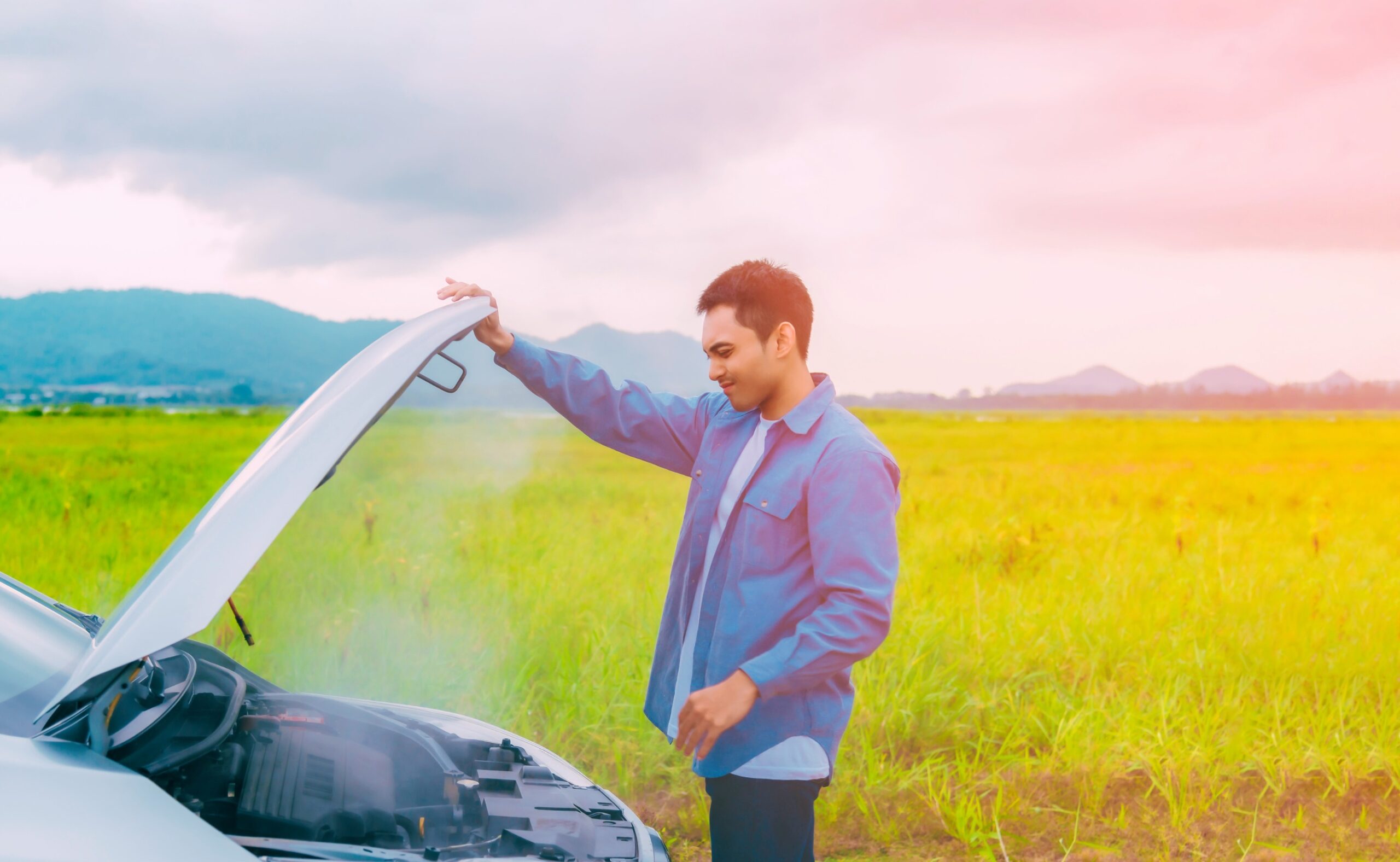 Asian young man having trouble car engine overheating and have smoke