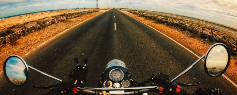 Anonymous biker riding motorcycle on highway in countryside with nice views