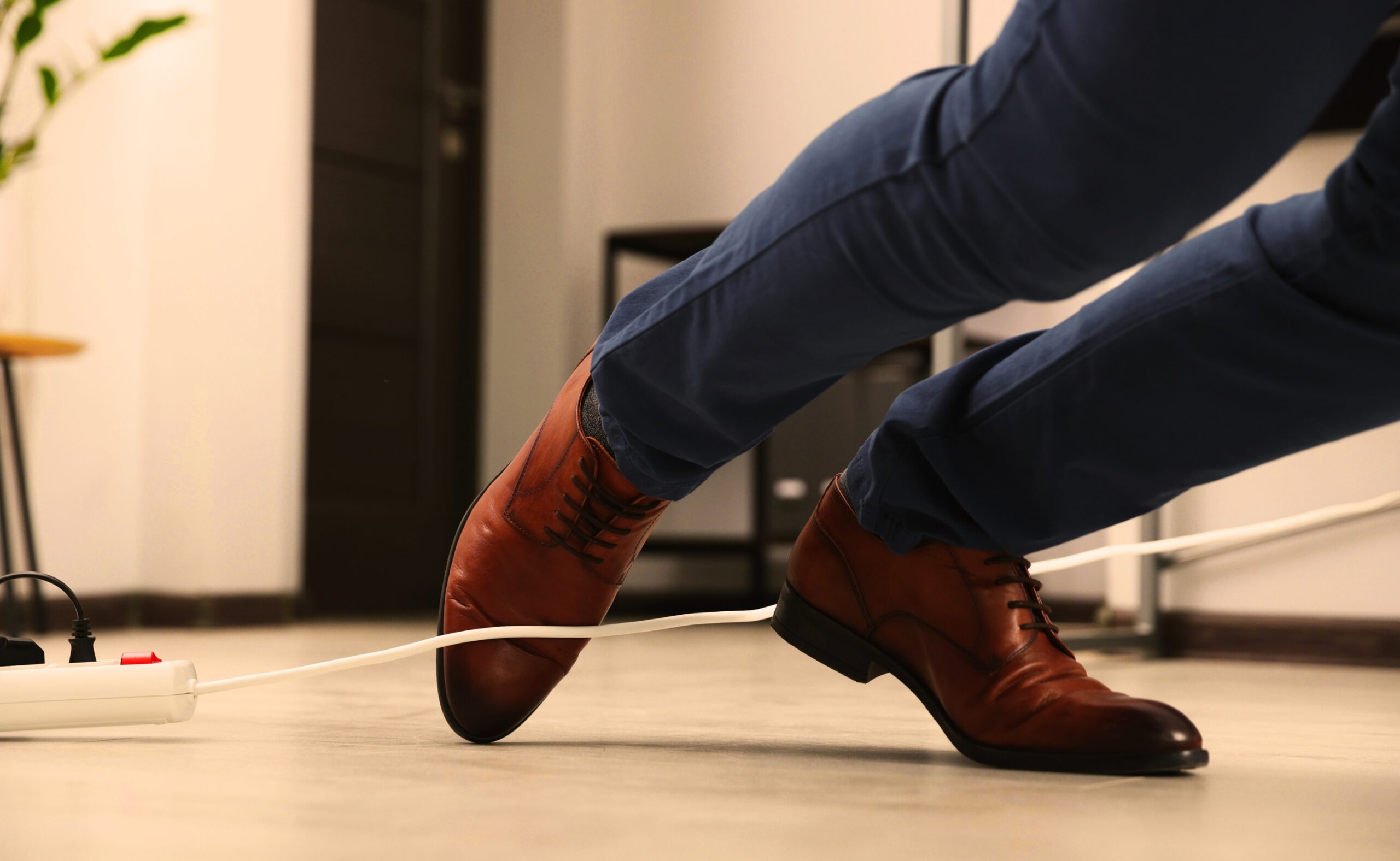 man tripping over cord in the office