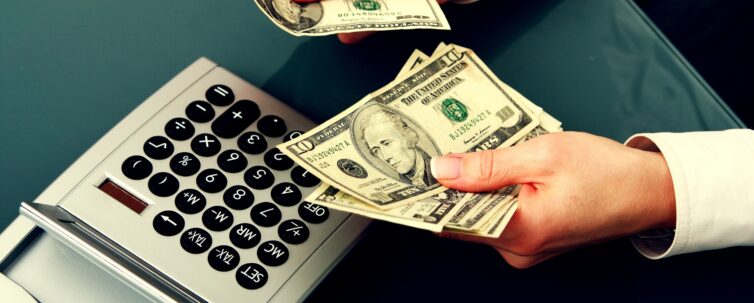 man with money on hand. there is a calculator on the table