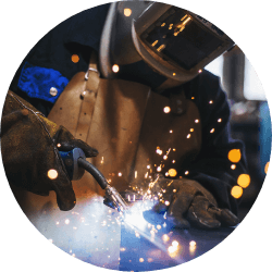 worker welding metal with sparks in factory